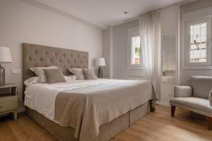 ein Schlafzimmer mit einem großen Bett und einem Stuhl in der Unterkunft Charming Avenida América in Madrid