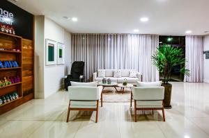 a living room with a couch and a table and chairs at Transamerica Fit Contagem in Contagem