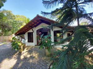 a house with a palm tree in front of it at Porto do Meio in Arraial d'Ajuda