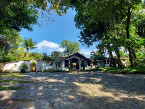 a house with a driveway and trees at Porto do Meio in Arraial d'Ajuda