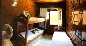 a room with two bunk beds in a brick wall at Casa chalé Gravatá in Gravatá