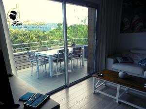 维琪奥港Résidence Cala Sultana N62 - 4 pers avec Piscine chauffée- accès privé à la Plage de SANTA GIULIA的阳台设有带桌椅的客厅 更多27张照片