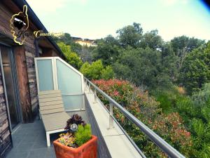 een balkon met een bank en bloemen op een huis bij Résidence Cala Sultana N62 - 4 pers avec Piscine chauffée- accès privé à la Plage de SANTA GIULIA in Porto-Vecchio