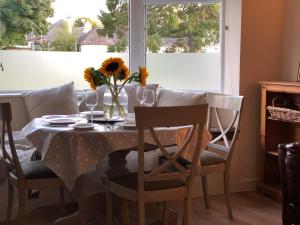 a table with a vase of sunflowers on it at Nurse's Cottage in Tomintoul