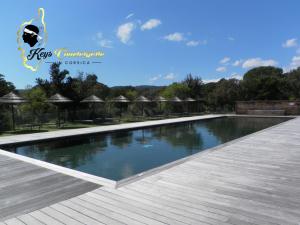维琪奥港Résidence Cala Sultana N62 - 4 pers avec Piscine chauffée- accès privé à la Plage de SANTA GIULIA的一座大型游泳池旁设有木甲板