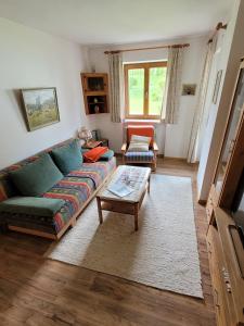 un soggiorno con divano e tavolo di Ferienwohnung Steibis / Allgäu a Steibis