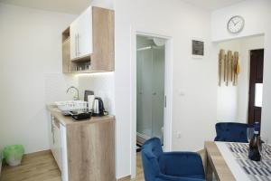 a kitchen and dining room with a table and blue chairs at Dvori Sky View E13 Kopaonik - free private parking in Kopaonik