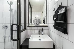 a white bathroom with a sink and a mirror at TRUNK (HOTEL) in Tokyo