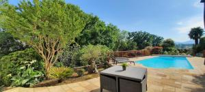 a swimming pool in a garden with a bench and trees at PARABISU TTIKIA "Petit Paradis" in Ascain