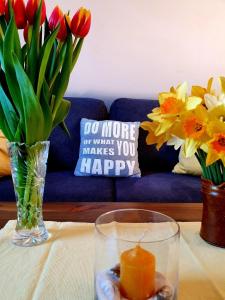 une table avec un vase de fleurs et une bougie dans l'établissement Bi üüs Itüüs, à Wenningstedt