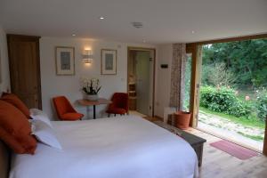 1 dormitorio con 1 cama blanca grande, mesa y sillas en Thatchcombe B&B en Wantage