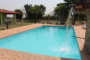 a swimming pool with a water fountain at Pousada Chácara Sonho in Hortolândia