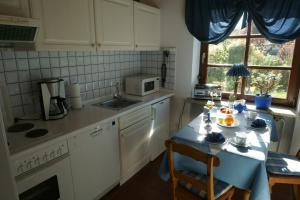 a kitchen with a table and a sink and a microwave at Carpe Diem III 1323 in Landkirchen