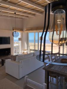 a living room with a white couch and a table at Ojos de la Viuda in Punta Del Diablo