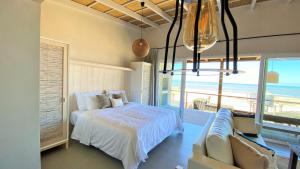 1 dormitorio con cama y vistas al océano en Ojos de la Viuda en Punta Del Diablo