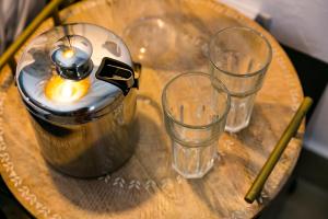 3 bicchieri e un bollitore per il tè su un tavolo di legno di Numero Uno Piñones a Loiza