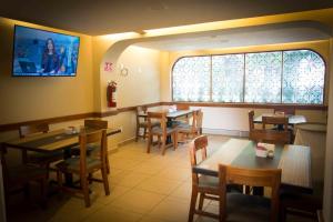 a restaurant with tables and chairs and a window at Hotel Antas in Mexico City