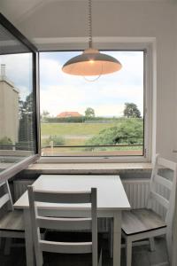 a table and chairs in a room with a large window at Haus Barbara - Schwimmbad und Sauna im Haus -Whg 4 in Grömitz