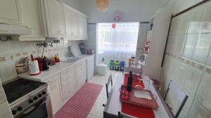 een keuken met witte kasten en een rood aanrecht bij Apartamento Tavira in Tavira +8 foto's