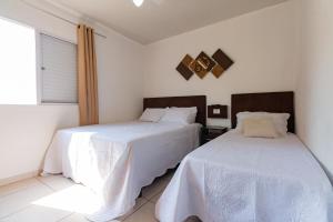 um quarto com 2 camas com lençóis brancos e uma janela em Brás - APARTAMENTO ACONCHEGANTE em São Paulo