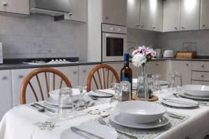 - une cuisine avec une table et une bouteille de vin dans l'établissement Ramzam - Spacious & Modern 3 bedroom apartment with roof terrace, à Marsaskala