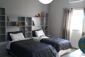 a bedroom with a bed and a book shelf at Ramzam - Spacious & Modern 3 bedroom apartment with roof terrace in Marsaskala +29 photos