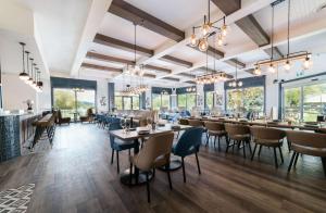 a restaurant with tables and chairs and windows at Prestige Harbourfront Resort, WorldHotels Luxury in Salmon Arm
