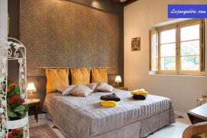 a bedroom with a large bed with yellow pillows at La Jacquière in Chaumont-sur-Loire