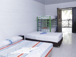 a bedroom with two beds and a balcony at Villa Palmeras Hotel Campestre in Espinal