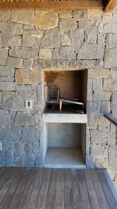 a stone wall with a bench in front of a table at Ojos de la Viuda in Punta Del Diablo