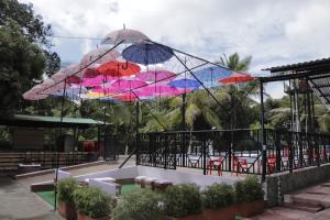 a group of umbrellas hanging over a pool at Villa Palmeras Hotel Campestre in Espinal