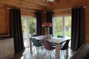 a dining room with a table and chairs and windows at Ferienhaus Harmonie in Twist