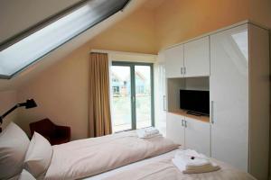 een slaapkamer met een bed en een dakraam bij Ostsee - Ferienhaus Nr 29a "Erste Reihe" im Strand Resort in Heiligenhafen