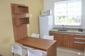 een keuken met een tafel en stoelen en een koelkast bij Resort Caldas Novas - Encontro das Águas in Caldas Novas