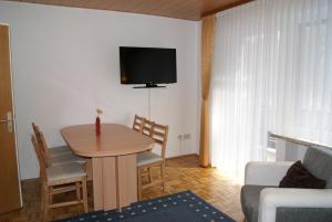 - un salon avec une table et une télévision murale dans l'établissement Ferienwohnung Schmidt, à Braunlage