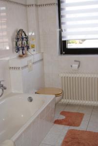 La salle de bains est pourvue d'une baignoire, de toilettes et d'une fenêtre. dans l'établissement Ferienwohnung Schmidt, à Braunlage