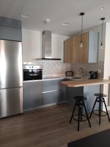 a kitchen with stainless steel appliances and a wooden counter top at La Rua 25 in Castro-Urdiales