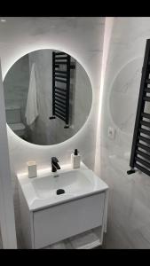 a bathroom with a white sink and a mirror at La Rua 25 in Castro-Urdiales