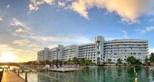 a large building next to a body of water at Exclusivos Apartamentos con playa privada in San Andrés