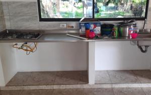 a counter in a kitchen with a stove and a window at Cabañas El Olimpo in Necoclí +47 photos