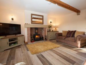 a living room with a couch and a fireplace at Deerholme Cottage in Malton