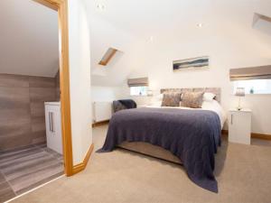 a bedroom with a bed and a large mirror at Deerholme Cottage in Malton