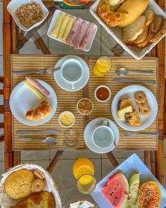 una mesa llena de diferentes tipos de alimentos para el desayuno en Pousada Jardim de Búzios, en Búzios