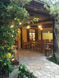 a patio with tables and chairs in a restaurant at Pousada Aroeira in Barra do Sahy