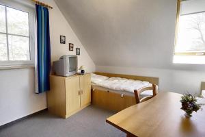 a room with a bed and a tv and a table at Am Deich 01 in Zingst