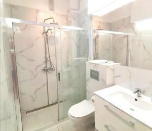 łazienka z prysznicem, toaletą i umywalką w obiekcie Metro Wilson Apartment w Warszawie