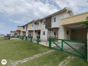a row of houses with a green fence at Pousada Belas Praia Imbituba in Imbituba