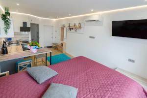 a bedroom with a pink bed and a kitchen at Mini-Smart 2 in Kyiv