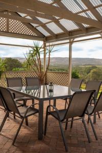 a table and chairs on a patio with a view at WayWood Wines Your Vineyard Getaway in McLaren Flat