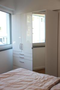 Casa Kronengarten Nr 3 في هيلدن: غرفة نوم بدولاب أبيض وسرير